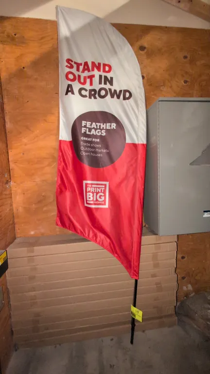 Curved sign stand with feather flag banner. Features multi-piece pole with flexible curved top and tension cord. Includes printed fabric feather flag