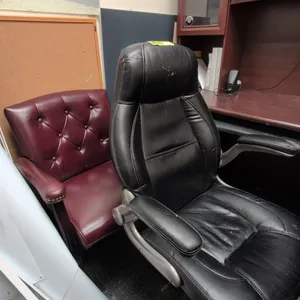 Assorted faux leather chairs. Includes (1) black high-back executive swivel chair on a 5-star caster base and (1) burgundy button-tufted guest armchai