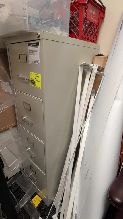 Metal 4-drawer vertical filing cabinet. Features putty finish, chrome pull handles, integrated label holders, and top lock mechanism. 15" x 52". Conte