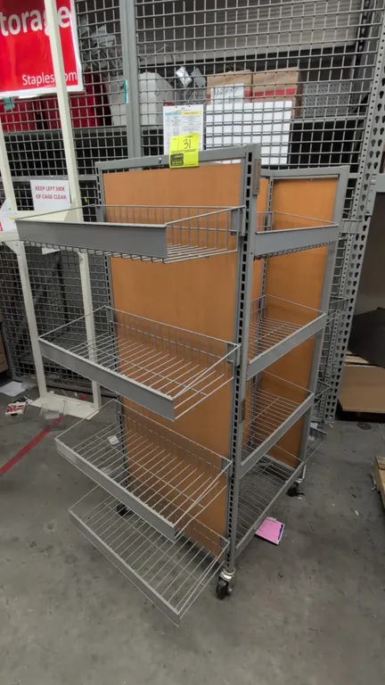 Metal 4-sided portable merchandise display rack. Features gray metal frame with wood-finish back panels and adjustable wire basket display shelves. Di