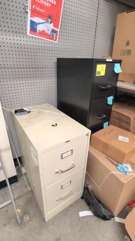 Metal vertical filing cabinets. Includes (1) Staples 2-drawer filing cabinet in putty finish (15" x 29") and (1) 4-drawer filing cabinet in black fini