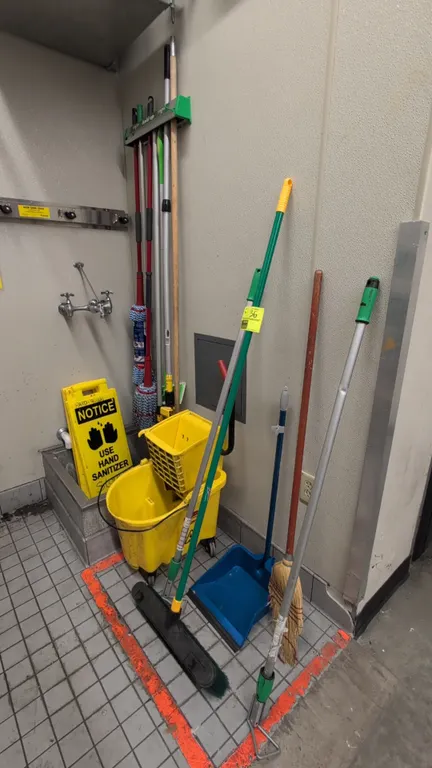 Assorted cleaning supplies package. Includes yellow mop bucket with wringer on casters, folding notice/caution floor signs, upright dustpan, corn broo