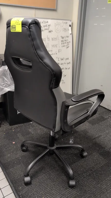 Vector 61108 ergonomic office chair. Features black and gray faux leather upholstery, padded armrests, integrated headrest cushion, tilt tension contr