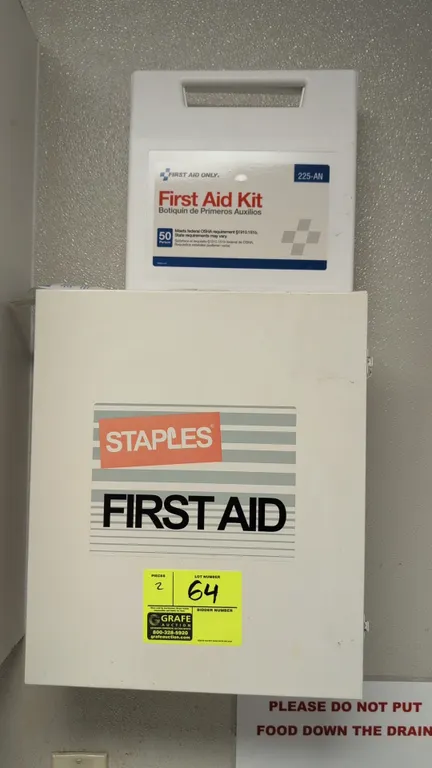 Assorted first aid kits. Includes a Staples wall-mount metal cabinet with 3 shelves and door organizer pockets, and a First Aid Only 225-AN 50-person