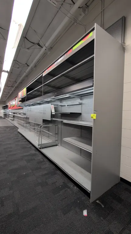 116'L of Madix wall shelving. 144"H uprights with 24" to 36"D base shelves. Features gray finish, pegboard backing, integrated canopy lighting, and vi