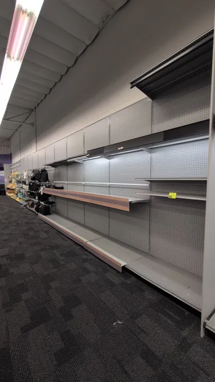 60'L of Madix wall shelving. 120"H uprights with 24"D base shelves. Features gray pegboard backing, integrated canopy lighting, and vinyl pull-down cu