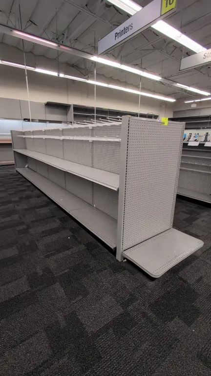 43'L of Madix gondola shelving. 60"H uprights with 18"D double-sided base shelves. Features gray finish, pegboard backing, upper shelves, and merchand