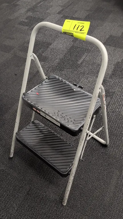 Cosco 2-step folding step ladder. Features tubular metal frame, molded slip-resistant steps, upper hand rail, and folding mechanism for compact storag