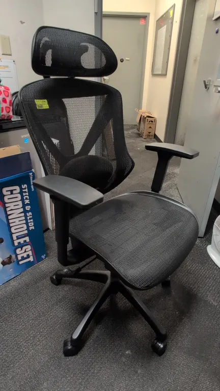 Ergonomic mesh office chair. Features black mesh back and seat, adjustable mesh headrest, lumbar support, and adjustable armrests. Mounted on a 5-star