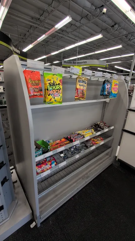 Double-sided laminate retail merchandise display rack. Features wire shelving, display peg hooks, price tag molding, and perforated metal side panel w