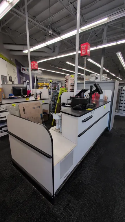 Laminate checkout lane. Features black countertop, white laminate body with black protective bumper trim, under-counter shelving and storage compartme