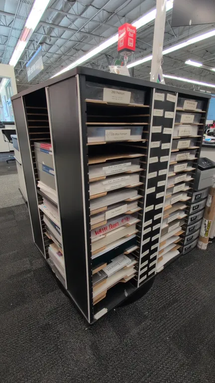 Laminate rotating paper rack. Features multi-tier slotted paper storage compartments with label channels and a black laminate finish. 33" x 48"H. Moun