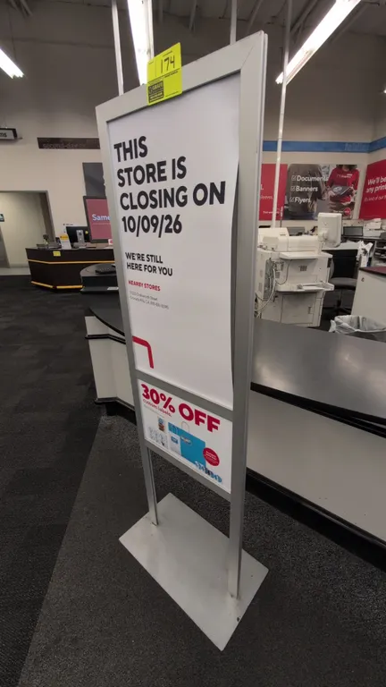 Metal floor sign stand. Features a silver-tone metal frame with dual display sections and a flat rectangular base. 22"W x 61"H. Signage not included.