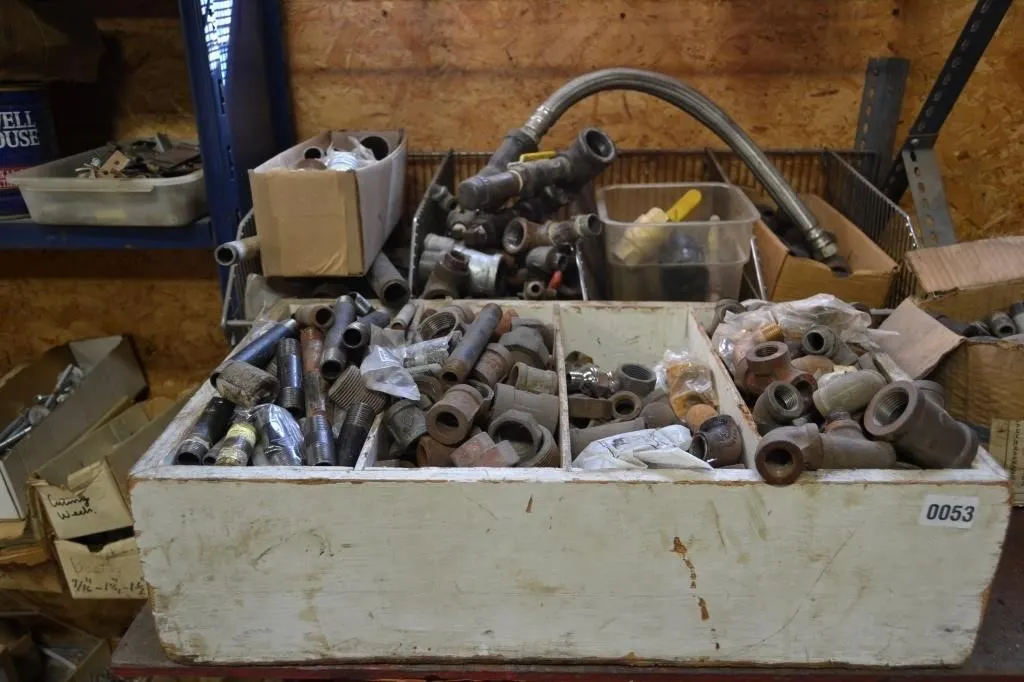 Red table with large assortment of pipe fittings