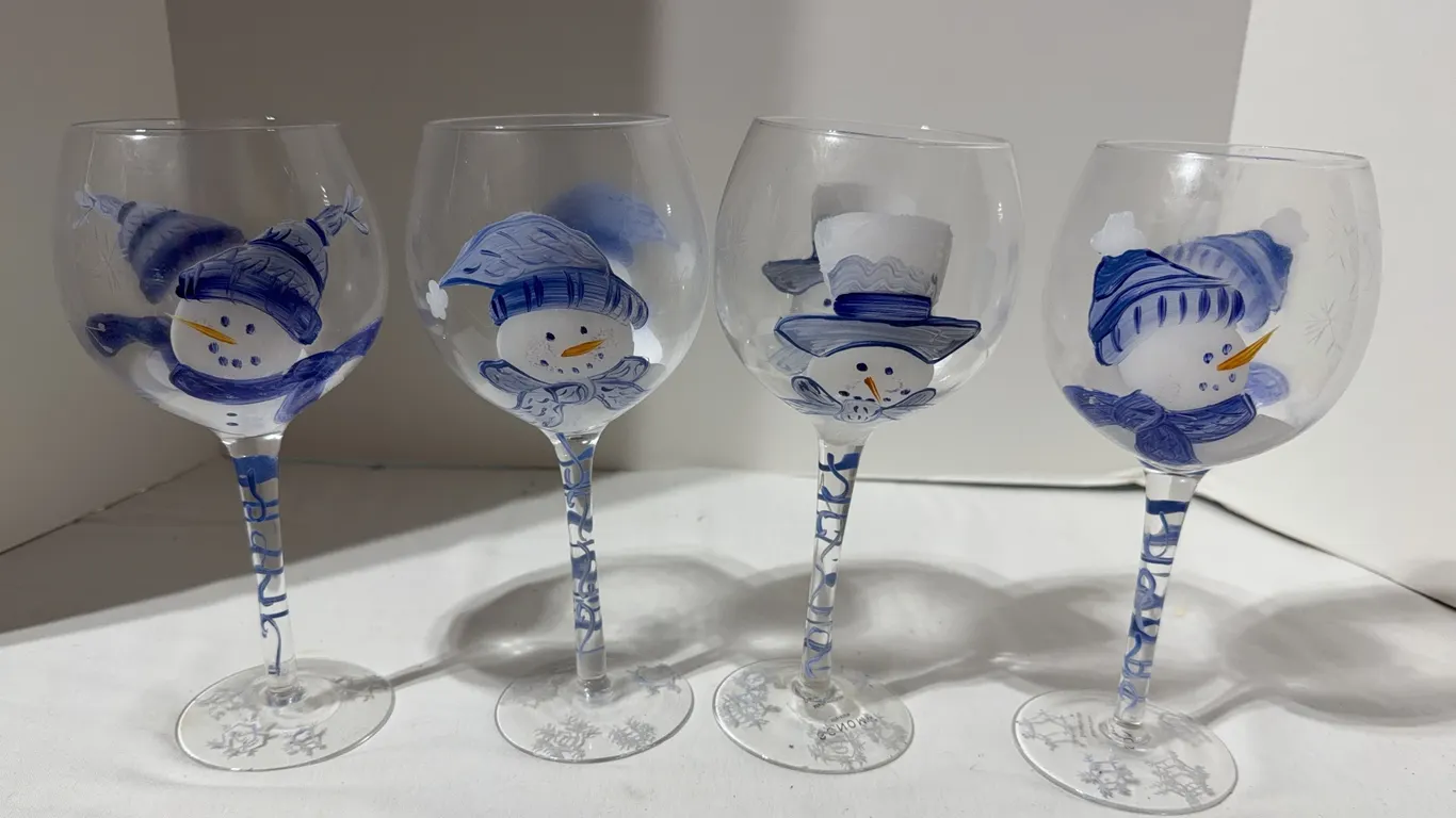 Set of four glass wine goblets featuring festive, hand-painted blue and white snowman designs