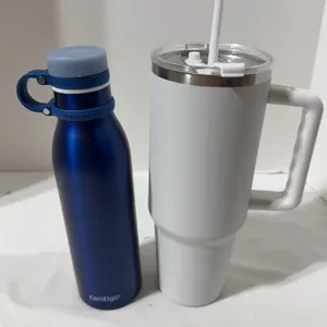 Pair of water bottles. One is a. white 40 oz stainless steel tumbler with a handle, lid, and straw A