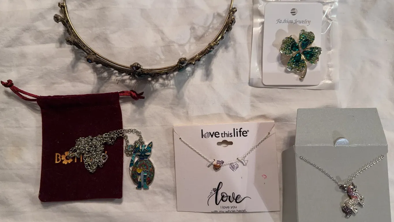 Assortment of jewelry, including necklaces, a tiara and a four leaf clover