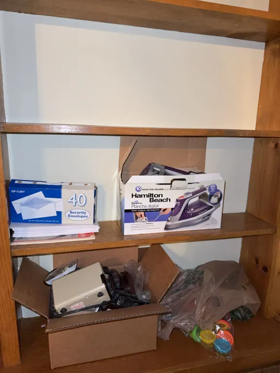 Shelf lot of office supplies and iron in box