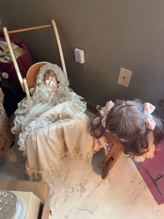 Porcelain dolls one in a carriage and bicycle