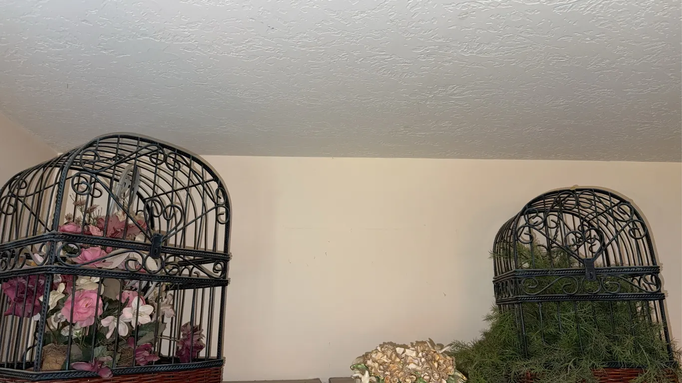 Large metal bird cages with flowers and greenery in them