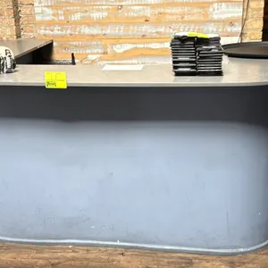 Hostess counter with base and countertop. Features a curved corner design, laminate countertop, and open rear interior. 90" x 40"H. Contents not inclu