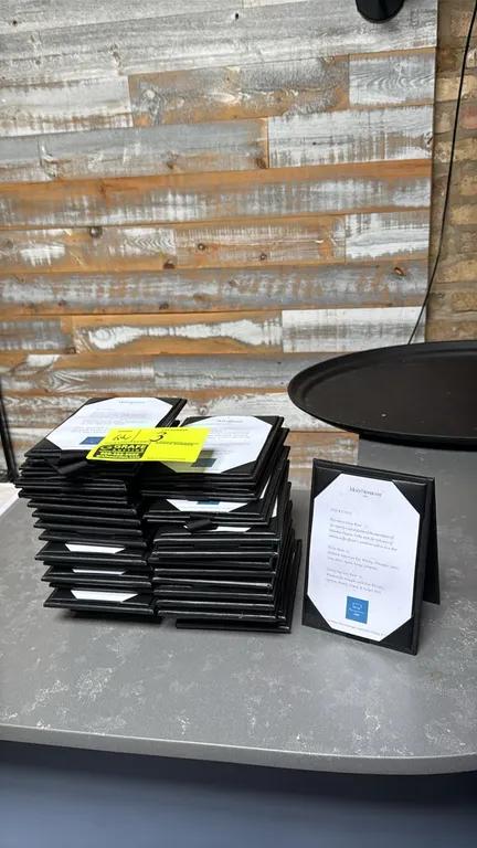 Tabletop drink menu holders. Features black folding A-frame tent construction, interior corner tabs to secure menu card inserts, and bottom connecting