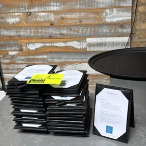 Tabletop drink menu holders. Features black folding A-frame tent construction, interior corner tabs to secure menu card inserts, and bottom connecting