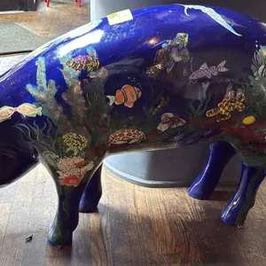 A Painted Pig Display Statue. A life-size decorative pig statue painted in a detailed marine and ocean reef motif over a deep blue ground, featuring t