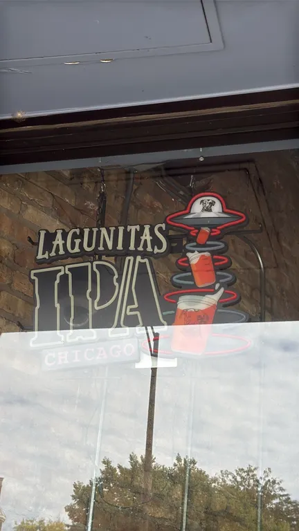 Lagunitas lighted beer sign. Features 'Lagunitas IPA Chicago' lettering with a UFO tractor-beam graphic and beer glasses motif. Equipped with metal fr