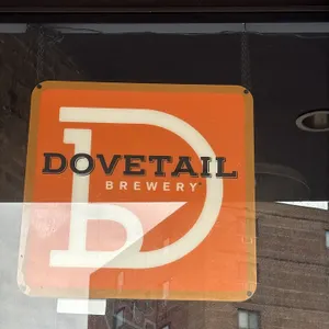 Dovetail Brewery lighted sign. Features orange graphic panel with Dovetail Brewery branding and rounded corners. Includes hanging chain.