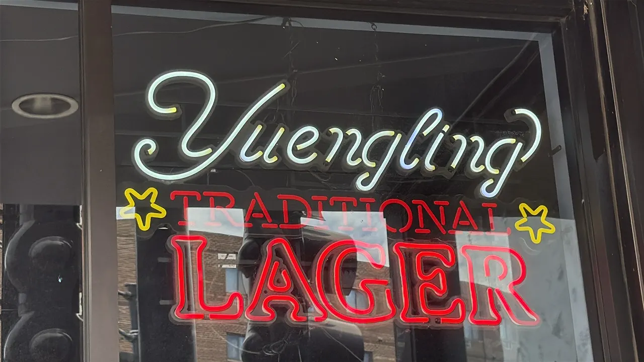 Yuengling Traditional Lager lighted beer sign. Features illuminated lettering reading 'Yuengling Traditional Lager' with yellow star accents, mounted
