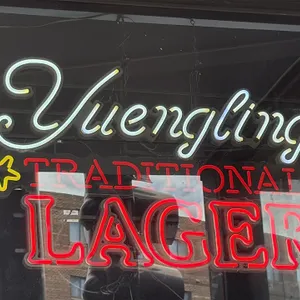Yuengling Traditional Lager lighted beer sign. Features illuminated lettering reading 'Yuengling Traditional Lager' with yellow star accents, mounted 