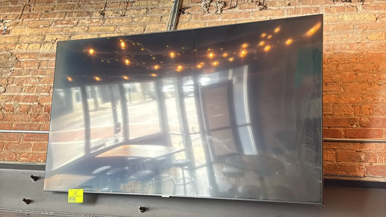Samsung 74" flat-screen TV. Features a slim bezel display. Wall mounted.