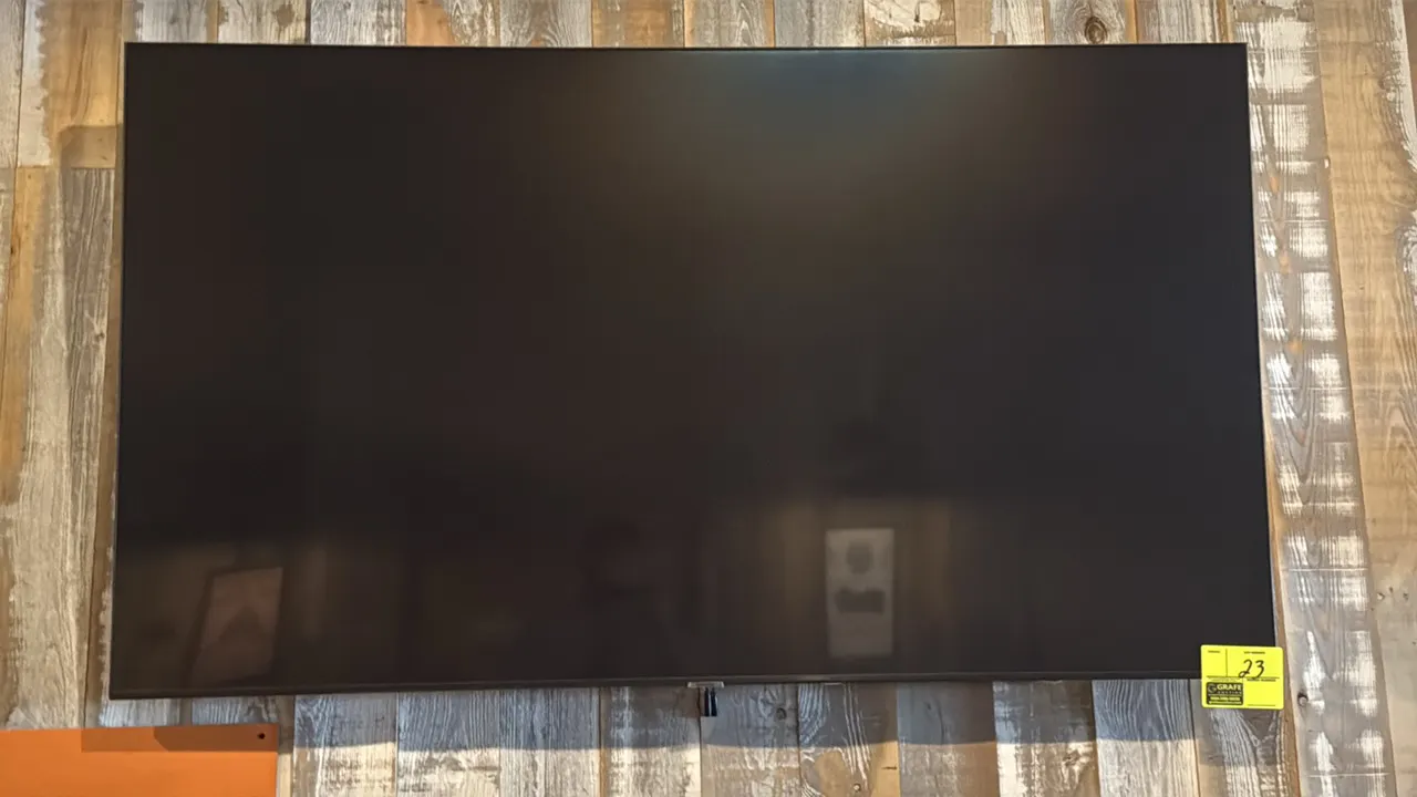 Samsung 65" flat-screen television. Features a slim bezel design. Wall mounted.