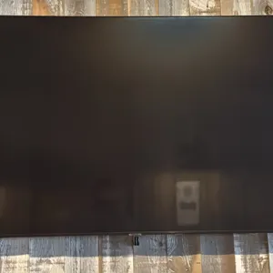 Samsung 65" flat-screen television. Features a slim bezel design. Wall mounted.