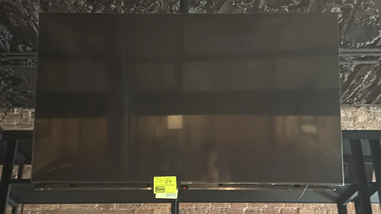 Samsung 65" flat-screen TV. Features a slim bezel design. Wall mounted.