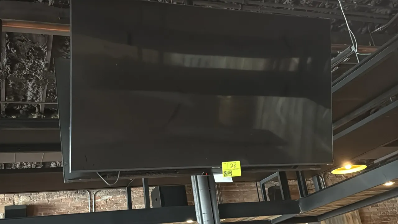Samsung 65" flat-screen television. Features a slim bezel design. Wall mounted. Remote not included.