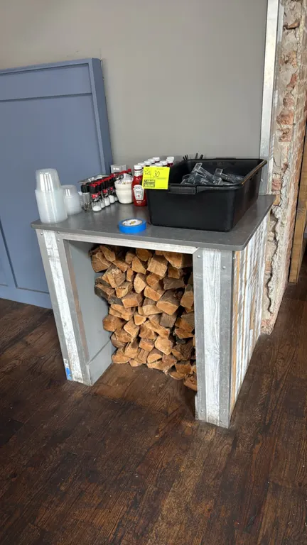 3' counter with base cabinet. Features a solid surface countertop, rustic paneled exterior with metal corner trim, and open lower storage alcove. Incl
