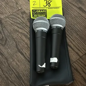 Shure SM58 dynamic vocal microphones. Features spherical mesh grilles and 3-pin XLR connections. Includes zippered storage pouch.