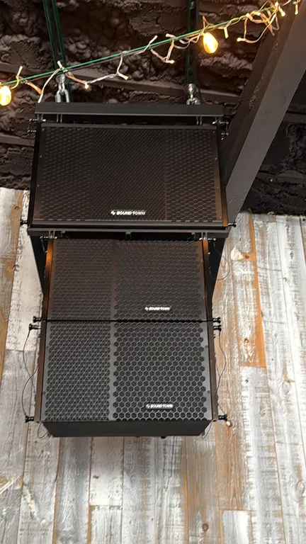 Sound Town powered line array speakers. Features black textured finish, perforated metal grilles, integrated rigging hardware, and rear amplifier conn