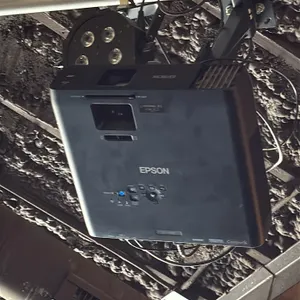 Epson projector with 9' projector screen. Features HDMI, VGA, LAN, and composite video inputs with integrated top controls. Paired with a 9' projector
