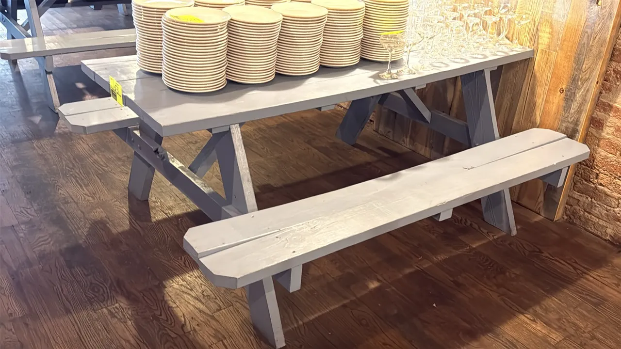 Painted wood picnic table. Features attached bench seating and gray painted finish. 71"L. Contents not included.