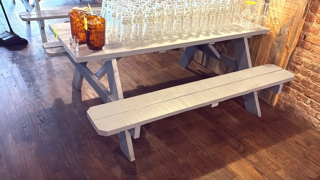 Painted wood picnic table. Features attached dual bench seating and gray painted finish. 71"L. Contents not included.