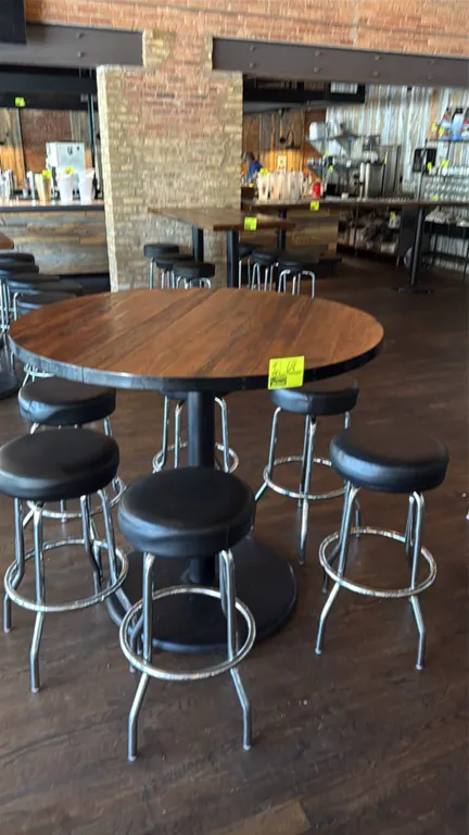 Bar height table with (5) swivel barstools. Features a 42" diameter round wood plank top with metal edge trim and a black metal pedestal base. Include