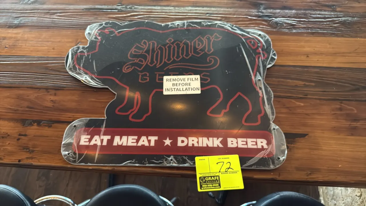 Shiner Beers lighted advertising sign. Features pig-shaped silhouette design with 'Shiner Beers' and 'Eat Meat ★ Drink Beer' graphics, protective peel