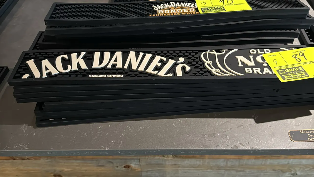 Jack Daniel's rubber bar mats. Features molded black rubber construction with raised white "Jack Daniel's Old No. 7 Brand" lettering and a textured sp