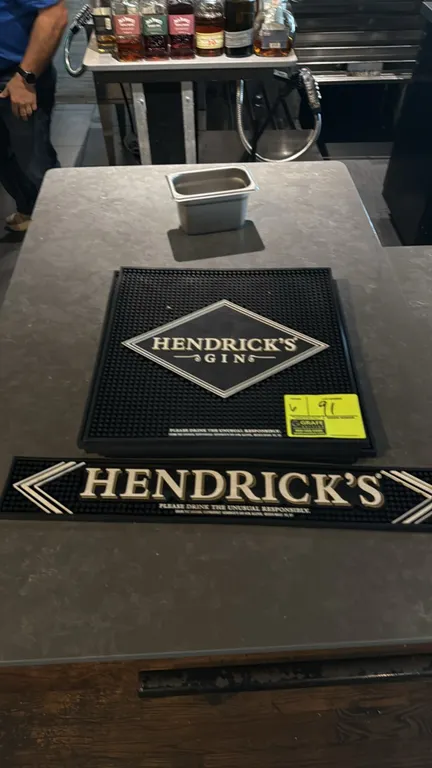Hendrick's Gin rubber bar mats. Features molded black rubber construction with raised perimeter containment borders, drainage nubs, and embossed Hendr