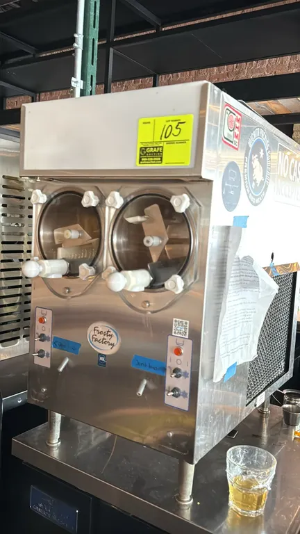 2023 Frosty Factory 217A 2-flavor frozen drink machine. Features dual clear dispensing cylinders, independent toggle controls, and stainless steel con