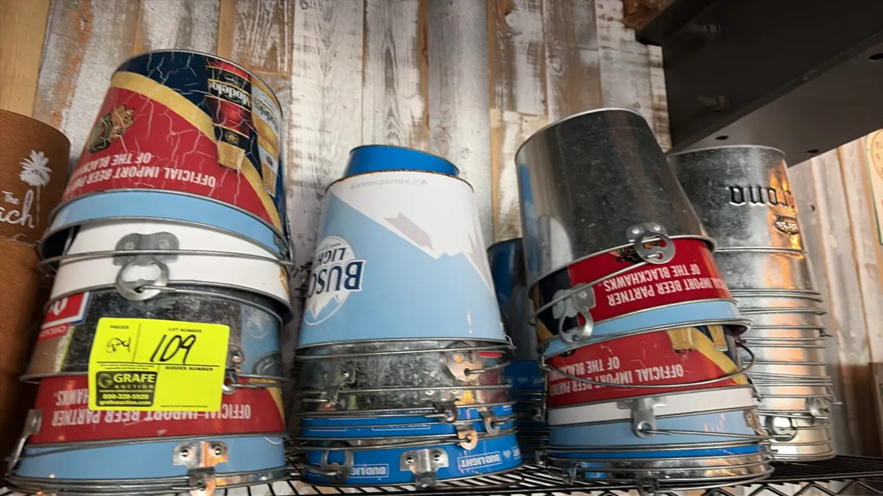 Assorted branded beer buckets. Features metal construction with wire bail handles and integrated bottle opener tabs. Includes various beer brands such