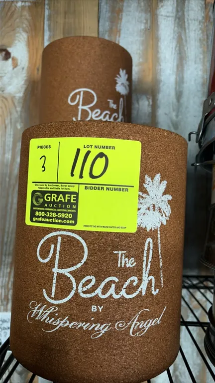 Whispering Angel "The Beach" cork wine buckets. Features molded cork construction with white printed "The Beach by Whispering Angel" logos and palm tr